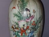 a vase with a painting on it sitting on a table