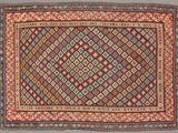 un tapis ancien orné d'un motif en losanges sur fond rouge