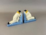 pair of ceramic figurines of a man and a woman sitting on a bookends