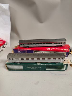trois trains miniatures assis l'un à côté de l'autre sur une table