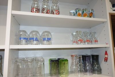 de nombreux verres et bocaux sur les étagères de la cuisine
