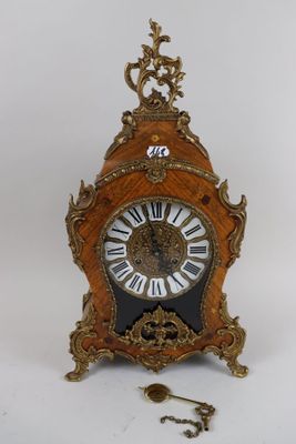 a clock that is sitting on a table with a key
