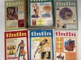 Quatre albums de Tintin sont posés sur une table