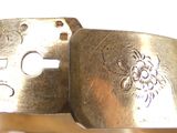 a close up of a metal bracelet with a flower design