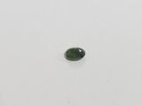 a green tourmaline stone on a white surface