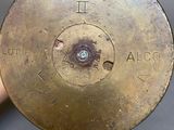 someone is holding a brass plate with a number on it