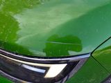 a close up of a green car ' s headlight and front bumper