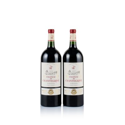 two bottles of red wine sitting next to each other on a white surface
