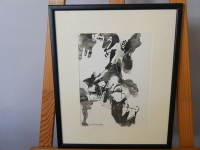 peinture représentant une œuvre abstraite en noir et blanc posée sur un chevalet en bois