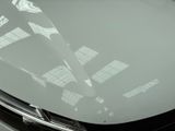 a close up of the hood of a car with the sun shining through the windshield