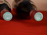 two bottles of wine sitting on a red cloth