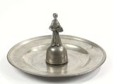 un plateau en argent sur lequel est posée une figurine