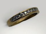 a close up of a gold ring with diamonds on a white background