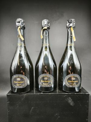 trois bouteilles de champagne posées sur une boîte noire