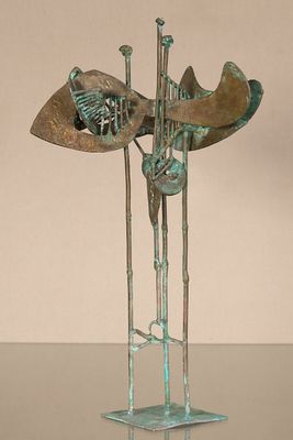 bronze sculpture of a fish on a stand with a hat on top