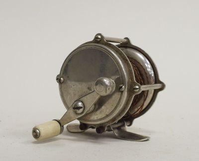 a small fishing reel with a wooden handle on a white surface