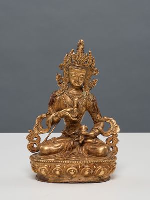 une statue en or représentant une femme assise sur un lotus