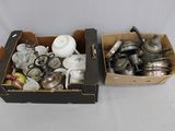 two boxes with silver items in them on a white surface
