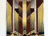 a wall hanging made of a tapestry with a cross on it