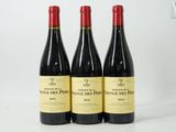 trois bouteilles de vin posées sur une table blanche