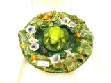 une assiette verte décorée d'une grenouille et de fleurs