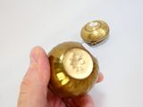 une personne tenant une boule dorée à laquelle est attachée une étiquette