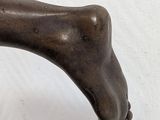a bronze statue of a dog with a bone on it ' s back