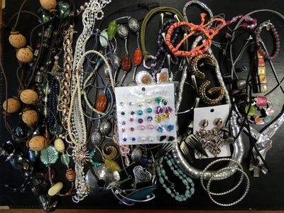 many different types of necklaces and bracelets laid out on a table