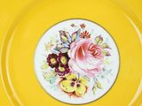 a yellow plate with a floral design on it