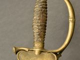 a close up of a sword with a gold handle on a gray background