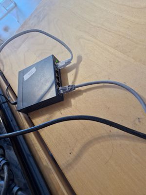 un ordinateur portable posé sur un bureau en bois, à côté d'un clavier