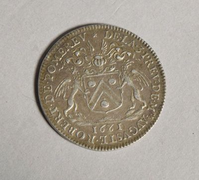 un gros plan d'une pièce d'argent sur laquelle figure un blason