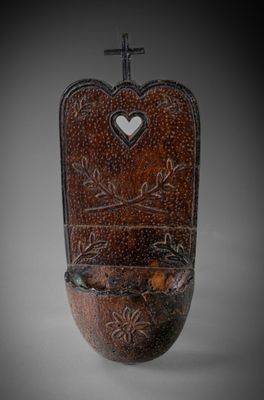 a small wooden toilet with a cross on top of it