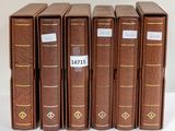 six livres marron sont alignés sur une surface blanche