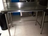 a stainless steel table in the middle of a kitchen