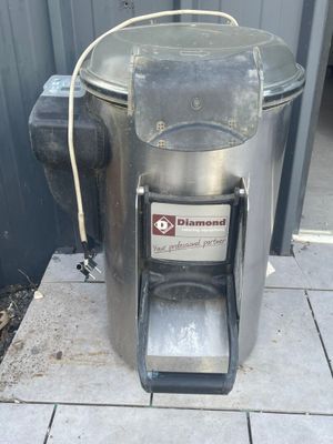 a metal trash can sitting on a sidewalk next to a building
