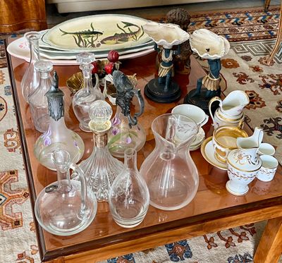 une table sur laquelle se trouvent de nombreux objets en verre