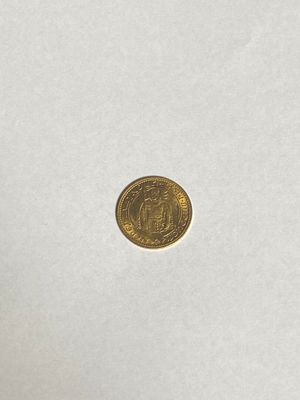 a close up of a gold coin on a white surface