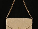 un sac à main beige muni d'une chaîne qui pend sur l'épaule