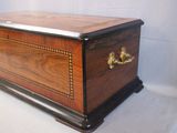 a small wooden box with a metal handle on it