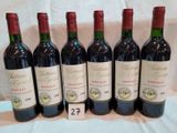 six bouteilles de vin rouge sont alignées sur une table