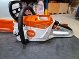 an orange and white chainsaw sitting on top of a table