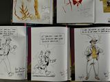 sketches of cartoon characters are displayed in a book on a table