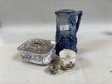 un pichet bleu et blanc posé à côté d'une tasse et d'une soucoupe