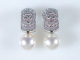 paire de boucles d'oreilles en perles et diamants sur fond blanc