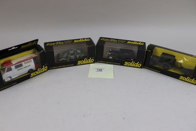 trois trains miniatures noirs et jaunes dans leurs boîtes, posés sur une surface blanche