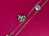 a close up of a necklace on a pink surface