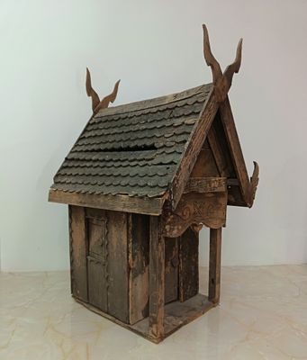 a small wooden birdhouse with two birds on top of it