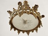 a gold ceiling light with a starburst in the center