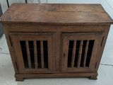 a small wooden cabinet with two doors on top of it